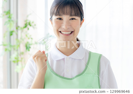 一個圍裙的年輕女士 129969646