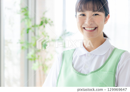 一個圍裙的年輕女士 129969647