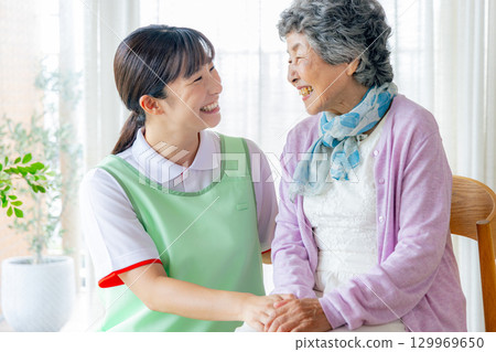 一位女性護理人員和一位年輕護理人員坐在椅子上 129969650