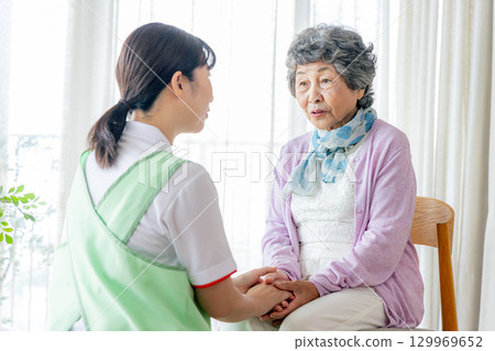 一位女性護理人員和一位年輕護理人員坐在椅子上 一位女性護理人員和一位年輕護理人員坐在椅子上 129969652