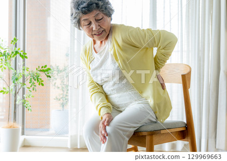 Senior woman with low back pain 129969663