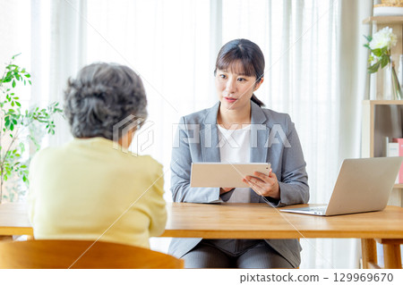 Senior woman talking to a salesman 129969670