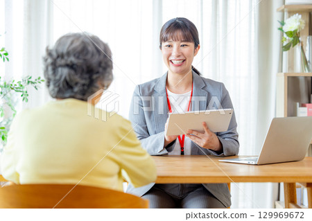 Senior woman talking to a salesman Senior woman talking to a salesman 129969672