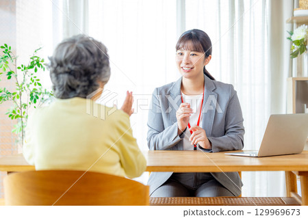 Senior woman talking to a salesman 129969673