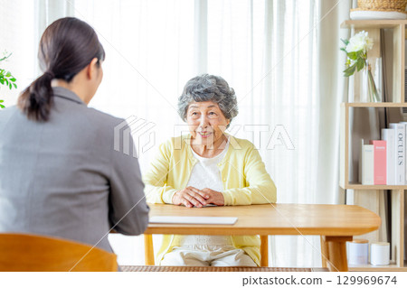 一位資深女士正在與推銷員交談 129969674