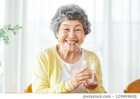 Senior woman drinking water 129969688