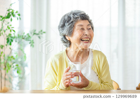 Senior woman drinking water 129969689