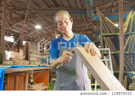 A veteran technician checks the dimensions of the lumber A veteran technician checks the dimensions of the lumber 129970352