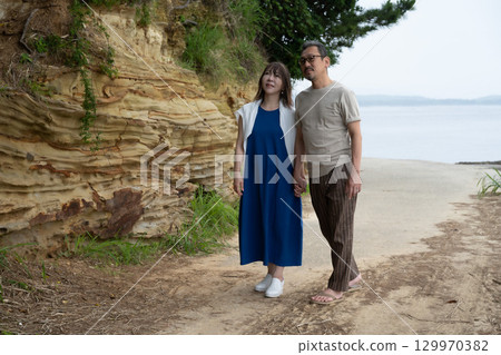 Two people walking along the sea at Himaka Island, Minamichita, Aichi Prefecture Two people walking along the sea at Himaka Island, Minamichita, Aichi Prefecture 129970382