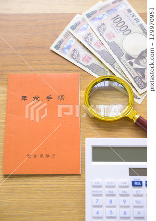 Pension book, calculator and magnifying glass (aligned) 129970951