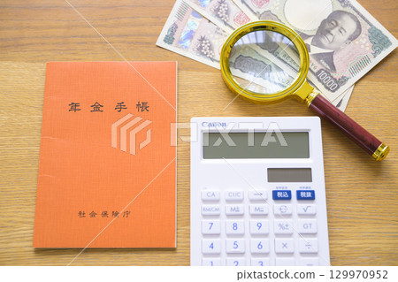 Pension book, calculator and magnifying glass (aligned) 129970952
