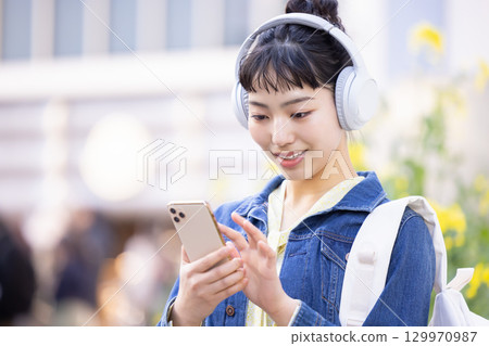 年輕女子戴著耳機聽音樂 129970987