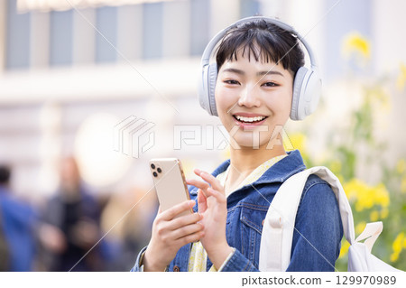 年輕女子戴著耳機聽音樂 129970989