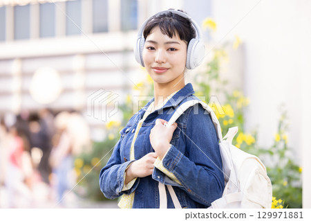 A young woman listening to music with headphones 129971881