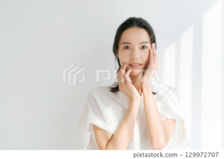 A woman smiling with her hand on his cheek 129972707