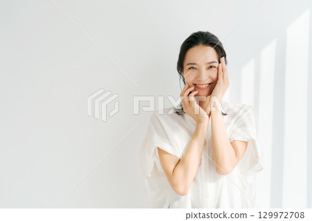 A woman smiling with her hand on his cheek A woman smiling with her hand on his cheek 129972708