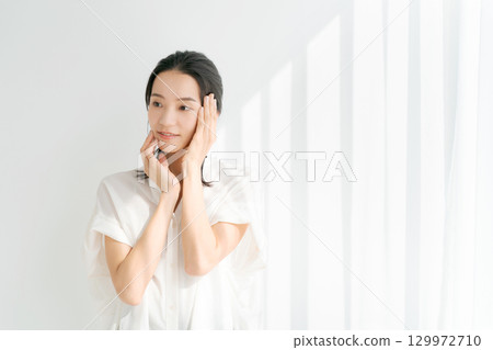 A woman smiling with her hand on his cheek A woman smiling with her hand on his cheek 129972710