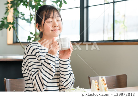 Girls drinking milk, hot milk, soup, juice, coffee for breakfast, lunch Girls drinking milk, hot milk, soup, juice, coffee for breakfast, lunch 129972818