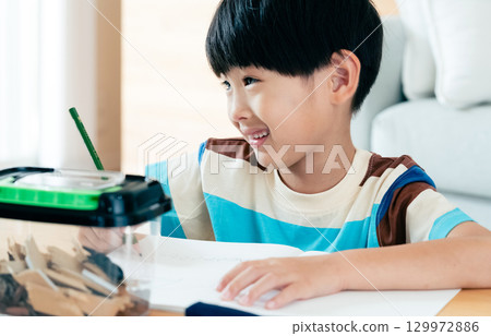 A boy in elementary school writing a diary of his observations of stag beetles 129972886