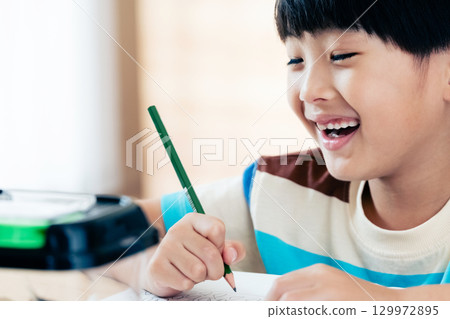 一名小學男孩正在寫日記,記錄他對鍬形蟲的觀察 一名小學男孩正在寫日記,記錄他對鍬形蟲的觀察 129972895