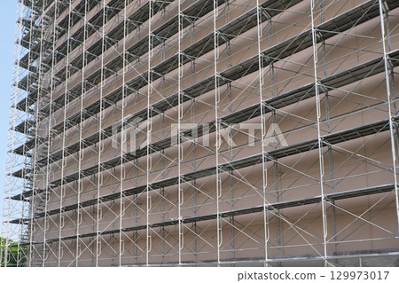 Construction scaffolding hung on a building 129973017