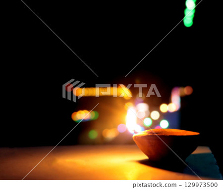 Traditional Clay Oil Lamp with Colorful Bokeh Lights at Night 129973500