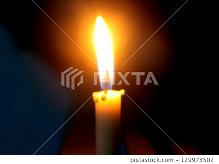Burning Candle Flame in Darkness Symbolizing Light and Hope Burning Candle Flame in Darkness Symbolizing Light and Hope 129973502