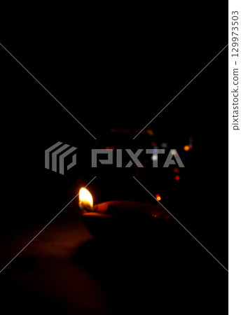 Burning Clay Oil Lamp in Darkness Symbolizing Light and Hope Burning Clay Oil Lamp in Darkness Symbolizing Light and Hope 129973503