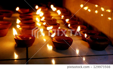 Rows of Lit Clay Oil Lamps Creating Warm Festival Glow Rows of Lit Clay Oil Lamps Creating Warm Festival Glow 129973508