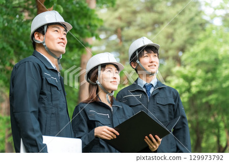 Male and female staff wearing helmets and work clothes at work sites, building sites, and construction sites Male and female staff wearing helmets and work clothes at work sites, building sites, and construction sites 129973792