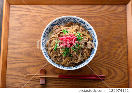 A hot beef bowl set meal and miso soup with pickles on a Japanese table. Image of a traditional Japanese lunch or dinner. A hot beef bowl set meal and miso soup with pickles on a Japanese table. Image of a traditional Japanese lunch or dinner. 129974121