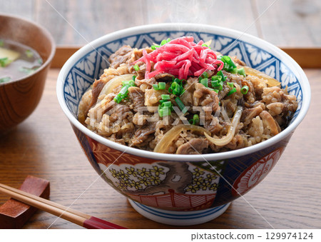 A hot beef bowl set meal and miso soup with pickles on a Japanese table. Image of a traditional Japanese lunch or dinner. 129974124