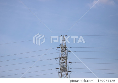 A crow perched on a steel tower A crow perched on a steel tower 129974326