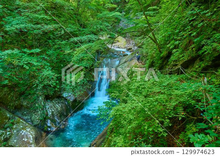 View of Sadazumi Falls and hikers in Nishizawa Valley, Yamanashi City, Yamanashi Prefecture 129974623