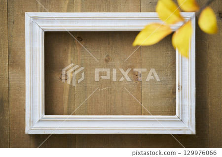 White picture frame hanging on a vintage wooden wall 129976066
