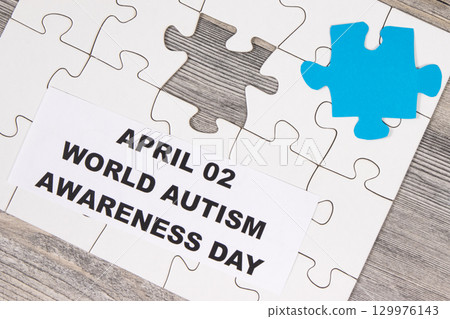 White and blue puzzle. Inscription April 02 World Autism Awareness Day White and blue puzzle. Inscription April 02 World Autism Awareness Day 129976143