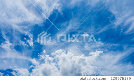 Solar halo phenomenon and many white clouds flowing in two layers 129976189