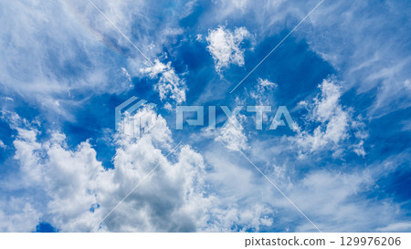 Solar halo phenomenon and many white clouds flowing in two layers 129976206