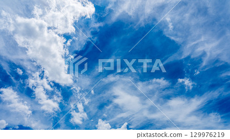 Solar halo phenomenon and many white clouds flowing in two layers 129976219