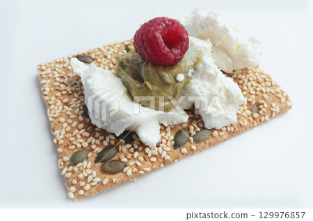 Crispy grain breads with seeds, cheese, ricotta and berries, marmalade. Breakfast and healthy eating. 129976857