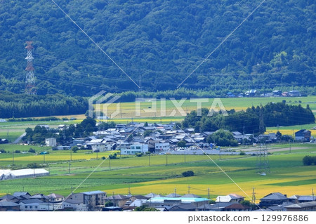Fields and houses spread out at the foot of the mountain Fields and houses spread out at the foot of the mountain 129976886