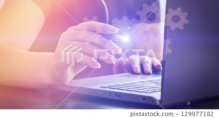 Woman configuring digital system on laptop 129977182