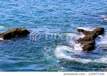 White waves rolling over the rocks White waves rolling over the rocks 129977394