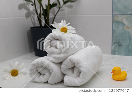 Relaxing Spa Setup With Rolled Towels, Flowers, and a Rubber Duck 129977647