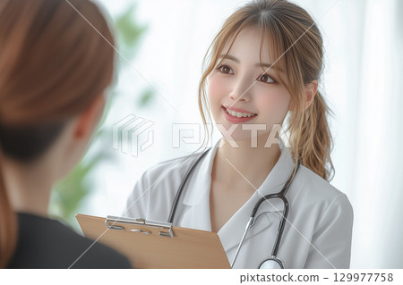 Medical image of a young female doctor smiling and talking to a patient Medical image of a young female doctor smiling and talking to a patient 129977758