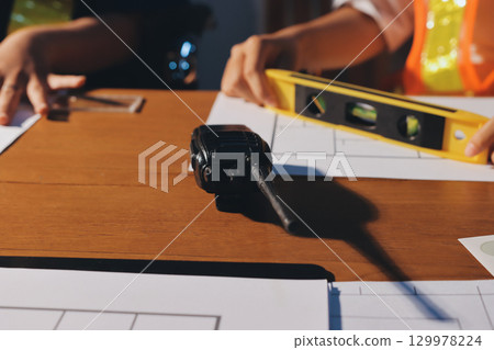 Closeup of team of industrial engineers meeting analyze machinery blueprints consult project on table in manufacturing factory. Working in manufacturing plant or production plant. Closeup of team of industrial engineers meeting analyze machinery blueprints consult project on table in manufacturing factory. Working in manufacturing plant or production plant. 129978224