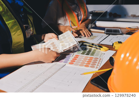 Closeup of team of industrial engineers meeting analyze machinery blueprints consult project on table in manufacturing factory. Working in manufacturing plant or production plant. 129978240