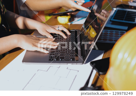 Closeup of team of industrial engineers meeting analyze machinery blueprints consult project on table in manufacturing factory. Working in manufacturing plant or production plant. 129978249