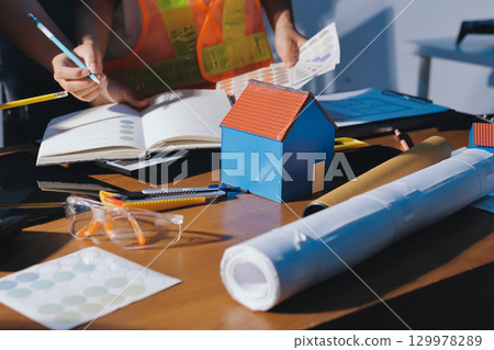 Closeup of team of industrial engineers meeting analyze machinery blueprints consult project on table in manufacturing factory. Working in manufacturing plant or production plant. 129978289