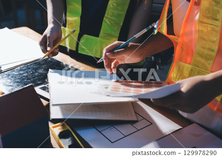 Closeup of team of industrial engineers meeting analyze machinery blueprints consult project on table in manufacturing factory. Working in manufacturing plant or production plant. 129978290